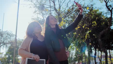 two women taking a selfie after shopping outdoors