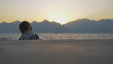 Junge-In-Einem-Hemd-Mit-Fledermäusen-Sitzt-Am-Meer