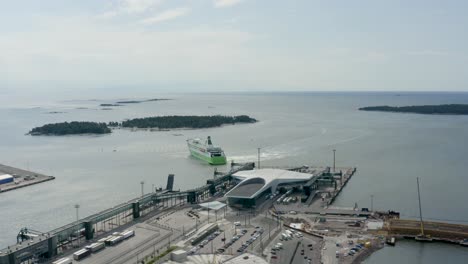 panorámica aérea lenta muy por encima del puerto de helsinki, finlandia, con un gran barco partiendo