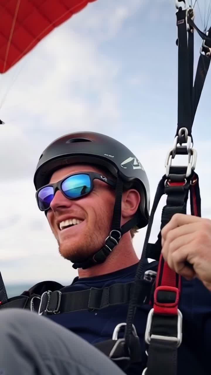 Happy young man with helmet and sunglasses, skydiving, enjoying the experience