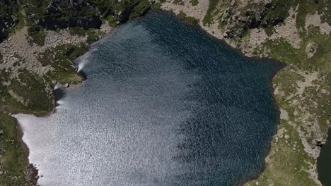 Top-down-high-drone-footage-of-one-of-the-Fontargente's-lakes-in-the-Pyrenees-mountains