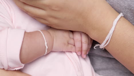 close-up of baby gripping and playing with fingers while drinking milk. a gentle and adorable moment captured