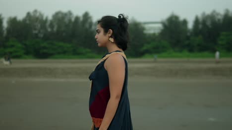 confident woman adjusting her hair on a cloudy day, outdoor shot with soft focus, evoking a sense of contemplation