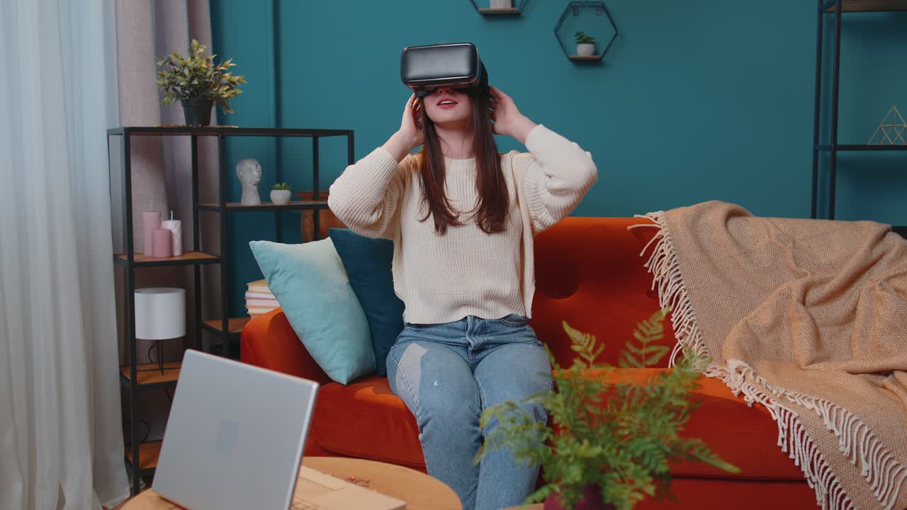 Young woman use virtual reality headset glasses at home enjoying video concept moving hands in air
