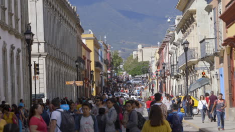 busy pedestrian street in oaxaca mexico. mountains in background