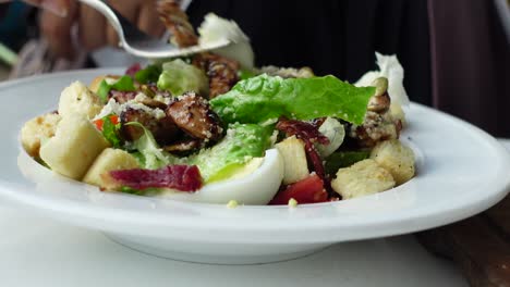 persona comiendo una ensalada césar