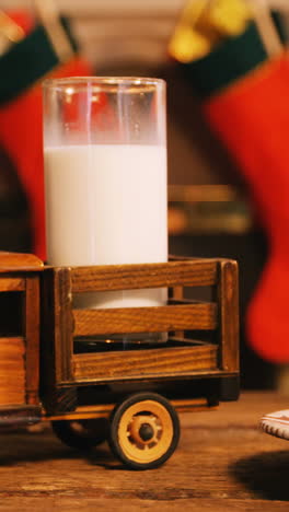 galletas de navidad en un plato y un camión de juguete con un vaso de leche