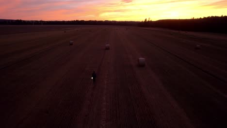 aerial drone view of a man walking in the middle of the field after harvest