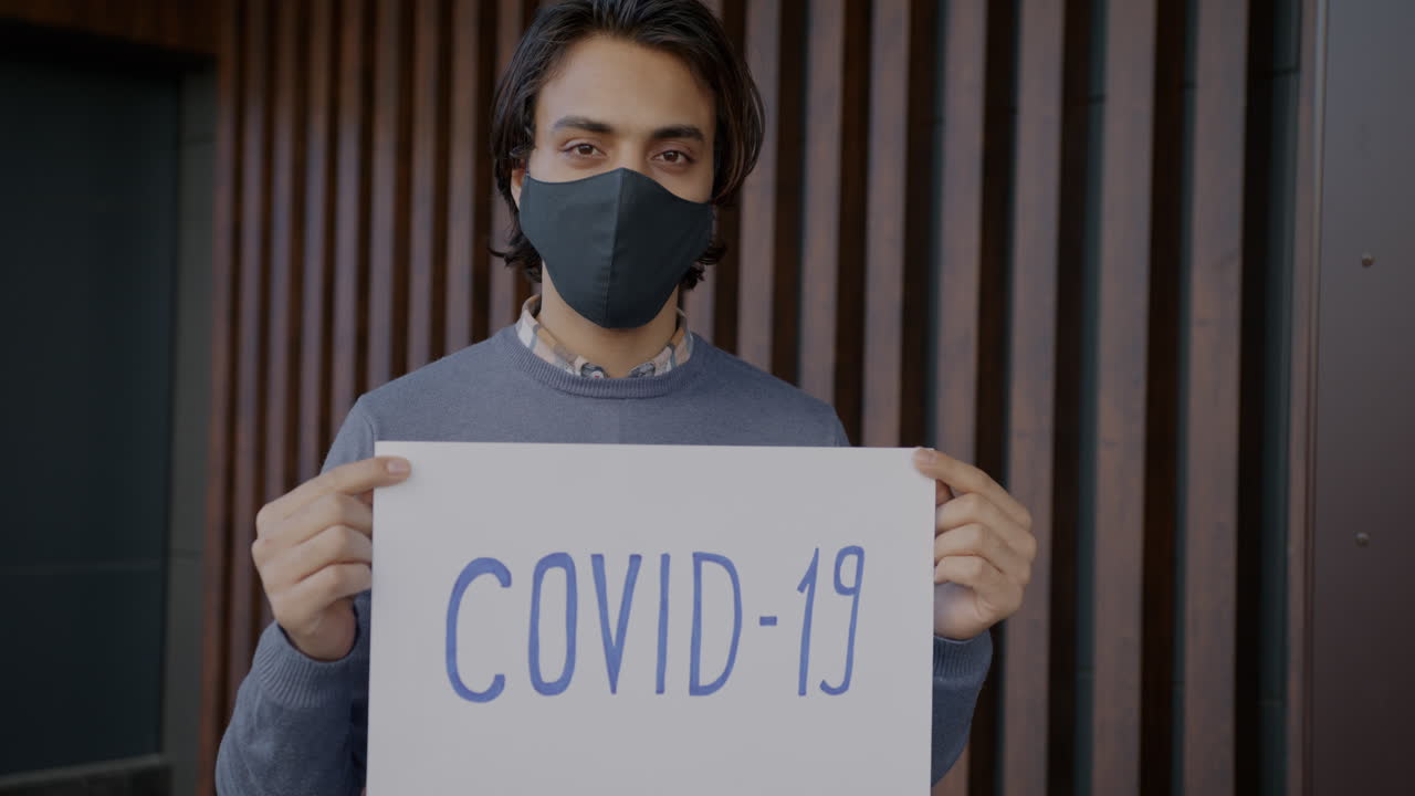 Man Holding COVID-19 Sign