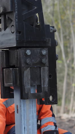 construction worker using heavy machinery to repair a metal beam