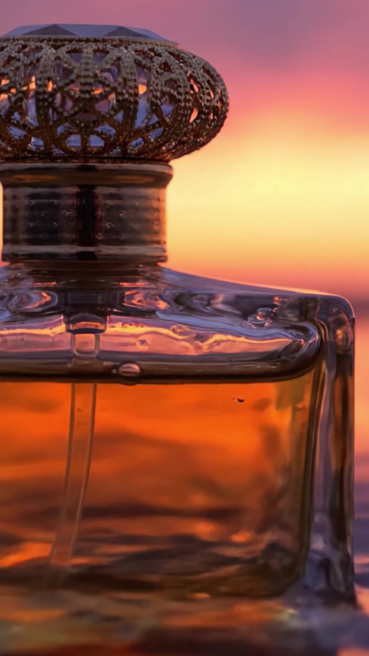 Un primo piano accattivante di un elegante flacone di profumo contro un tramonto mozzafiato, che evidenzia il design intricato e il lussuoso liquido ambrato al suo interno.