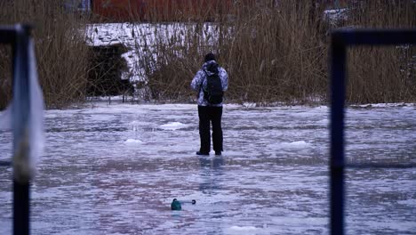 Ein-Fischer-Neckt-Einen-Fisch,-Der-Sich-Unter-Dem-Eis-Befindet