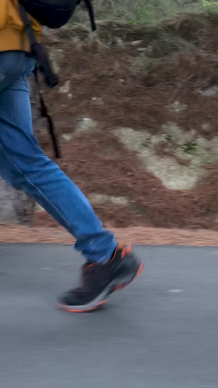 People Walking on a Road Alongside a Natural Embankment