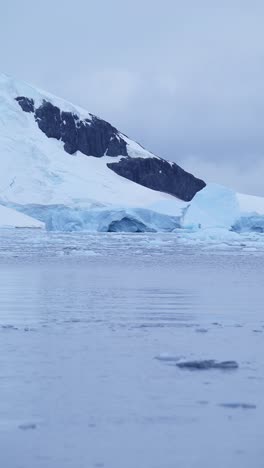 Winter-Mountains-Coastal-Scenery-in-Antarctica,-Cold-Snowy-Snow-Covered-Landscape-on-the-Coast-of-Antarctic-Peninsula-in-Vertical-Video-for-Social-Media,-Instagram-Reels-and-Tiktok