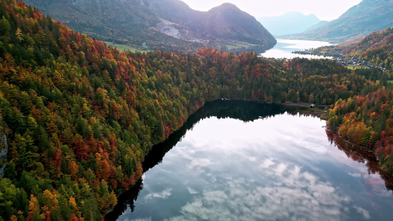 Aerial view of mirroring water and vibrant autumn trees at lake Toplitz in Austria