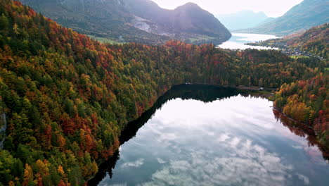 aerial view of mirroring water and vibrant autumn trees at lake toplitz in austria