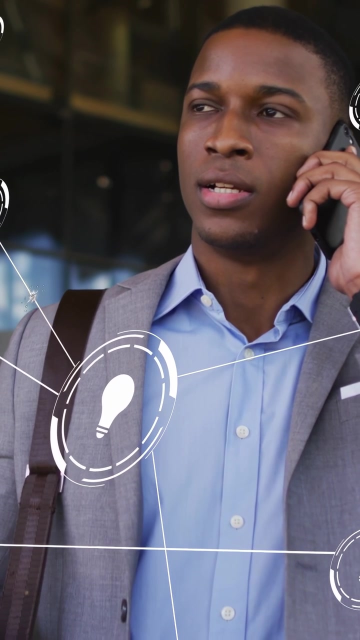 Vertical video: Businessman on phone speaking, starting AR bulb icons linking over glass, gesturing