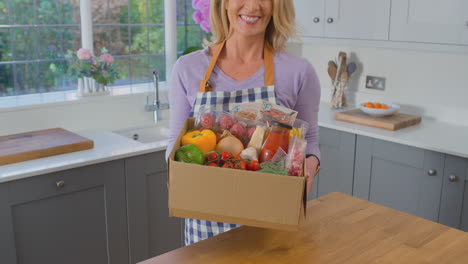 portrait of woman unpacking online meal food recipe kit delivered to home - shot in slow motion