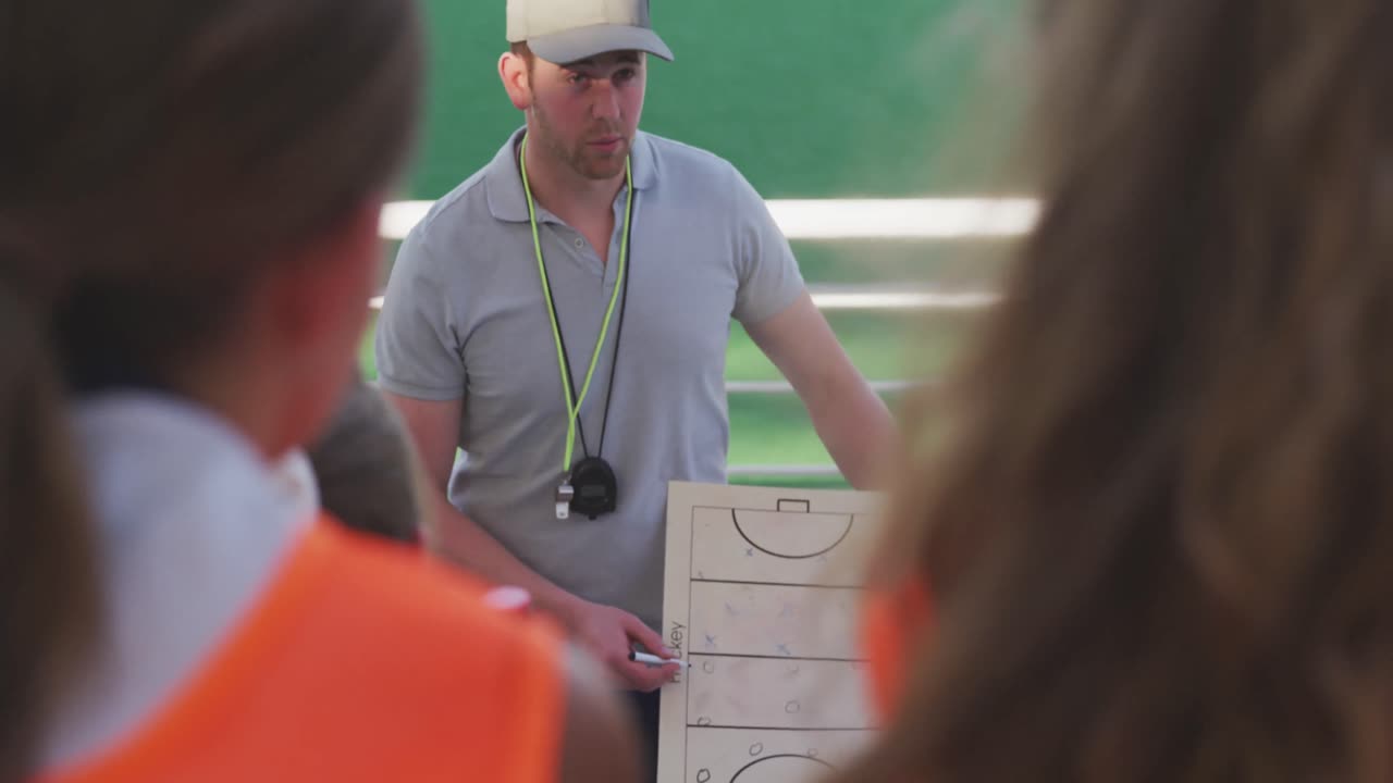 entrenador de hockey explicando el plan de juego con jugadoras