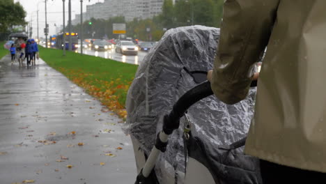 mum walking with baby on rainy autumn day