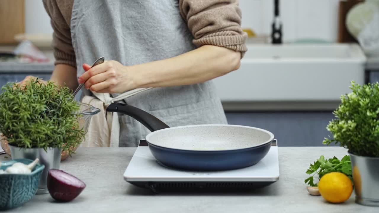 mujer vertiendo aceite en la sartén y haciendo albóndigas