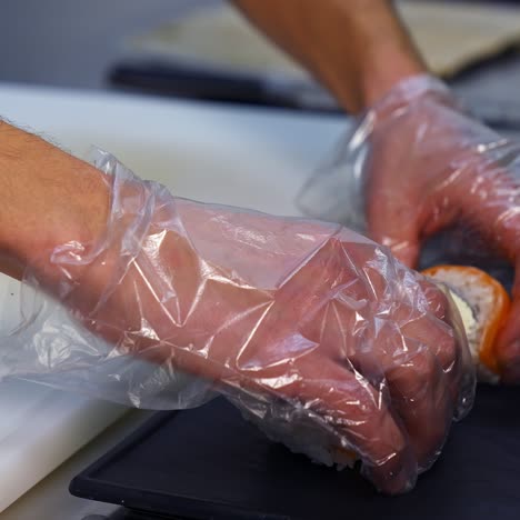 Hands of a cook serving sushi. Handmade delicious healthy sushi fish with rice. Sushi chef putting great sushi set on a serving plate