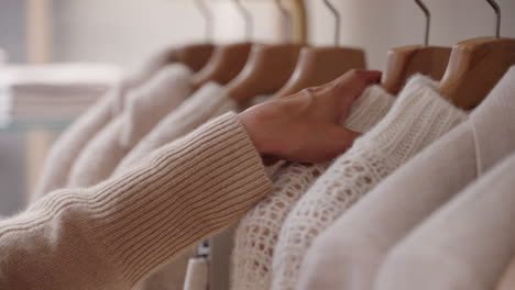 Closeup-of-a-woman's-hand-going-through-clothes-at-a-clothing-store