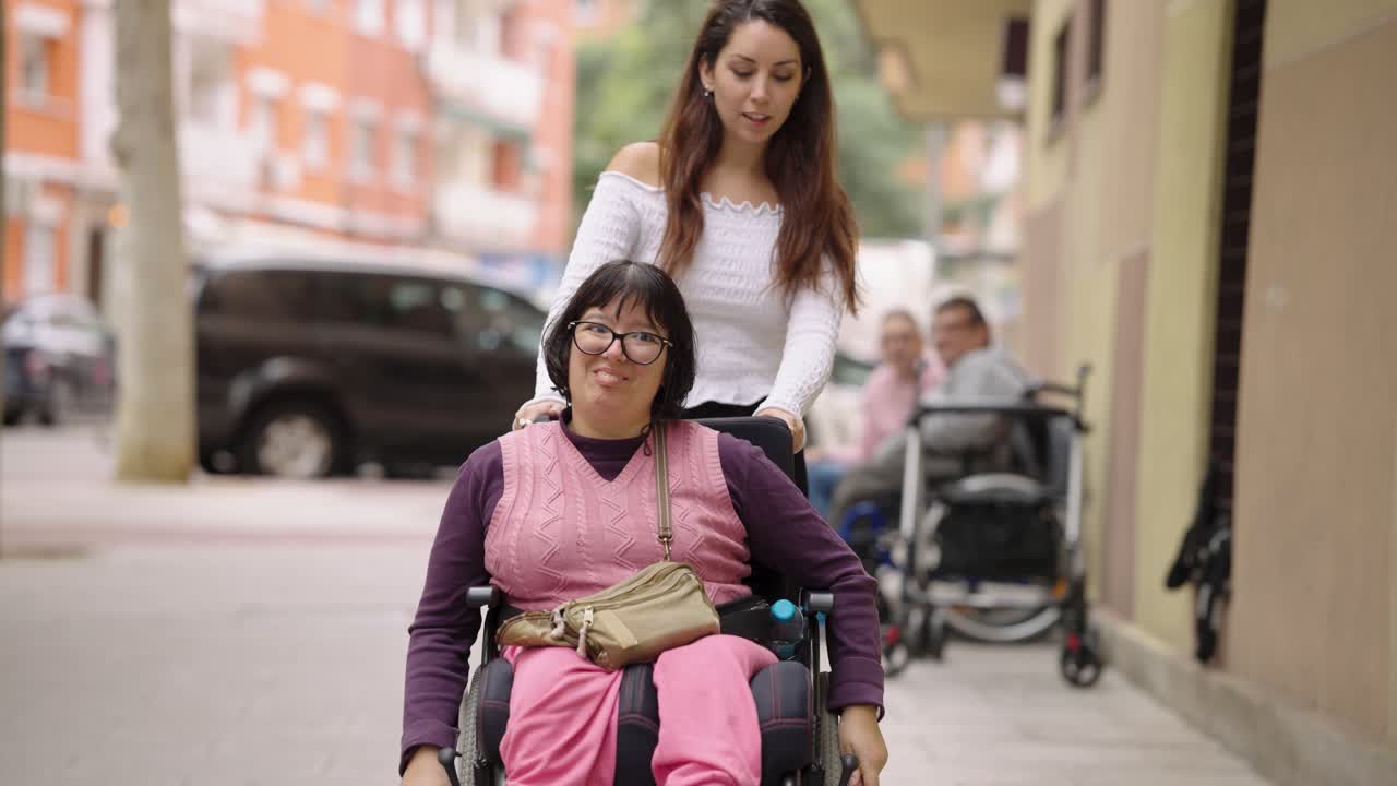 Woman Pushing a Person in a Wheelchair on the Street