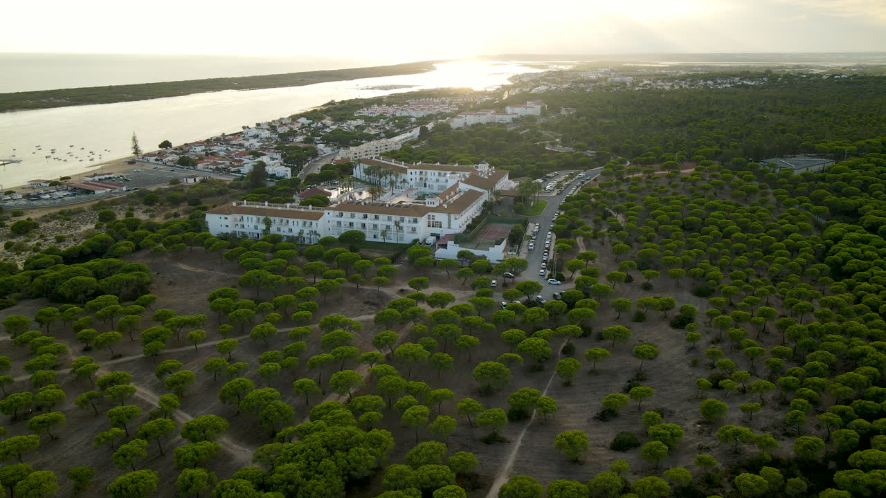 toma aérea del lujoso hotel garden playanatural en el rompido durante la puesta de sol en el fondo, españa