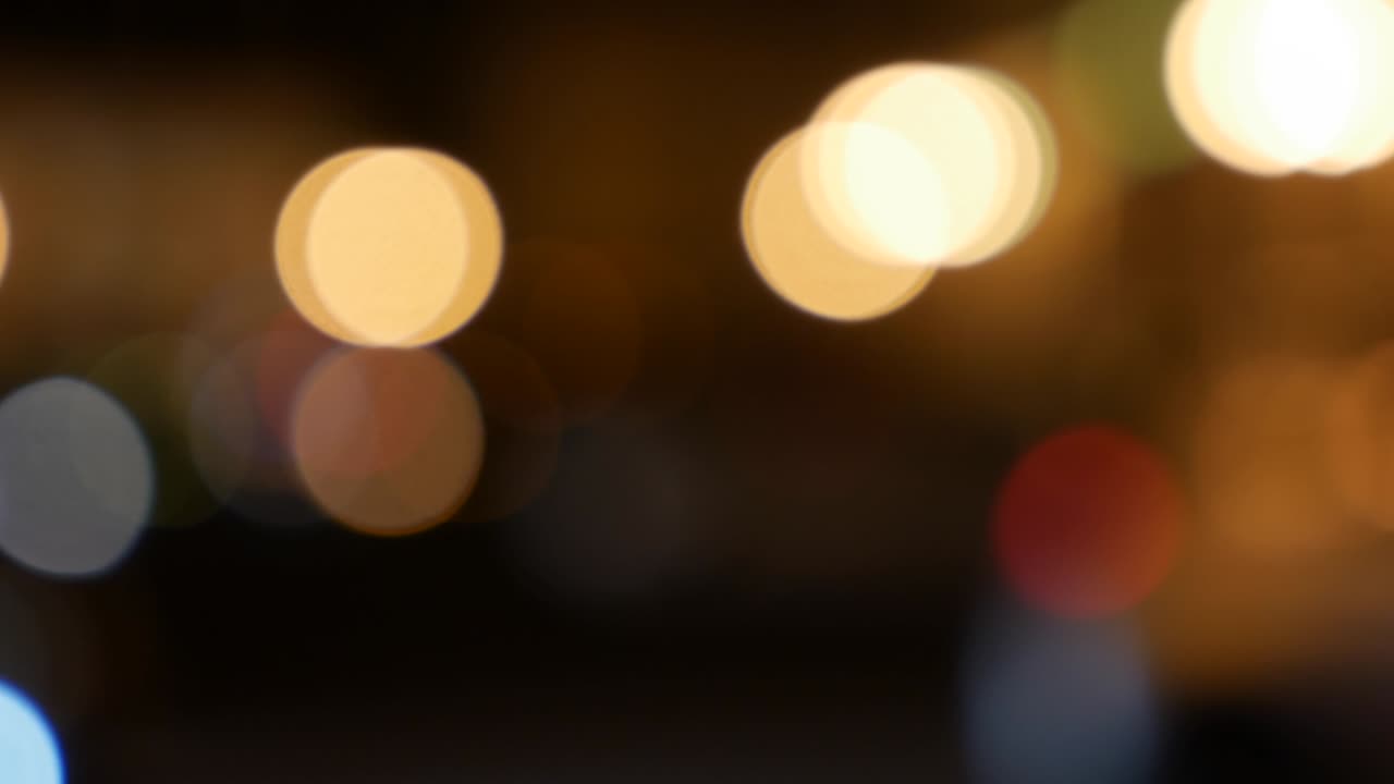 hermoso bokeh brillante en el fondo oscuro borroso por la noche. el redondo bokeh colorido brilla de las luces de los coches en la calle de la ciudad. fuera de foco con borroso. luces de la ciudad sin enfoque. bokeh de tráfico. concepto abstracto