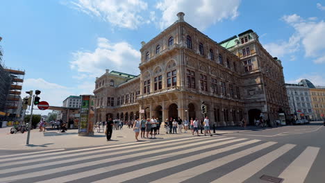 vienna, austria - june 9, 2025: exploring the historic buildings of wien. tourists enjoy a sunny day while visiting beautiful architecture in wien, austria. people stroll near an iconic theater