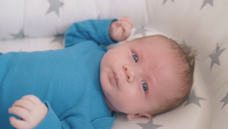 cute sad baby screams lying in cozy cocoon at home closeup