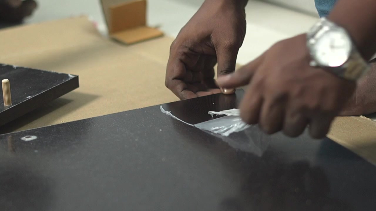 Removing plastic coating from wooden assemble diy table closeup shot