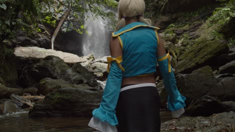 legs of an anime cosplayer girl as she walks towards the base of a waterfall