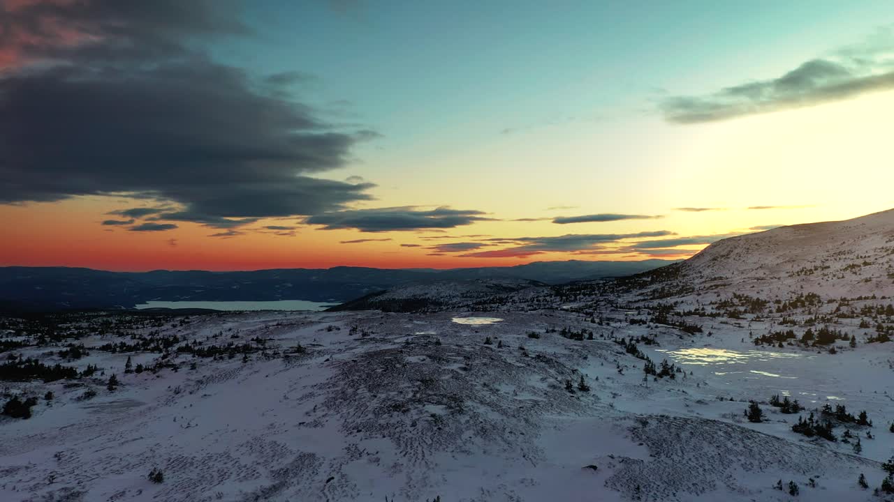 vista aérea sobre la tierra cubierta de nieve al anochecer alrededor de la montaña blefjell, telemark, noruega