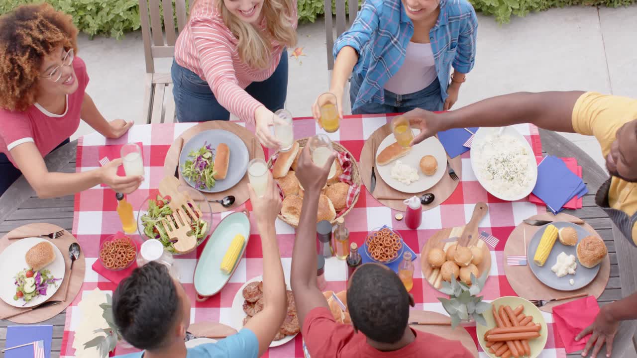 행복 한 다양한 친구 들 이 정원 에서 저녁 식사 테이블 에 토스트 를 하는 것, 느린 움직임