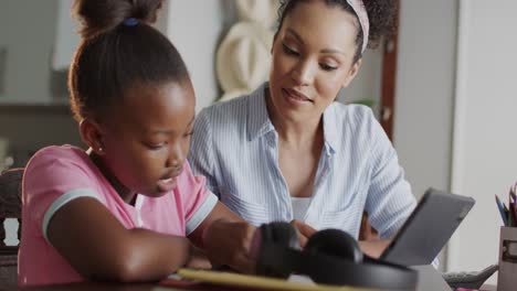 Glückliche-Afroamerikanische-Mutter-Und-Tochter-Nutzen-Tablet-Und-Machen-Gemeinsam-Hausaufgaben,-Zeitlupe