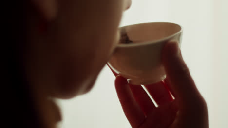 woman drinking tea by the window