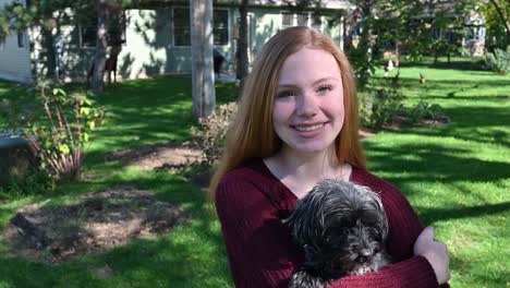 yorkie-poodle mix be held by her loving owner