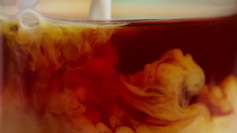 milk pouring into coffee and liquid moving