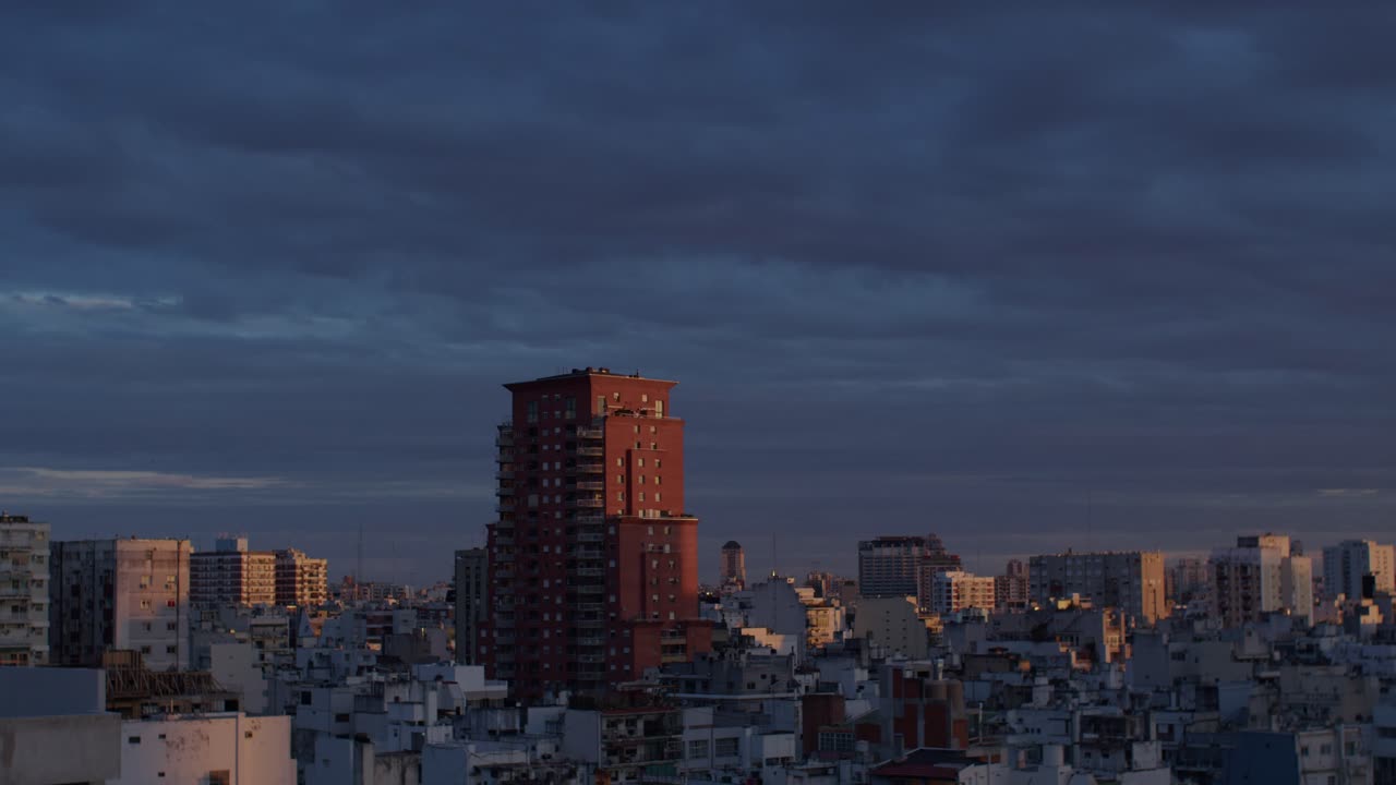 Buenos aires skyline at sunset with a red building standing out against dark clouds, aerial view