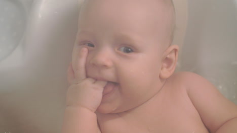 a closeup of a baby girl enjoying bathing