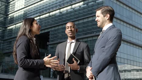 professional multiethnic coworkers discussing in street