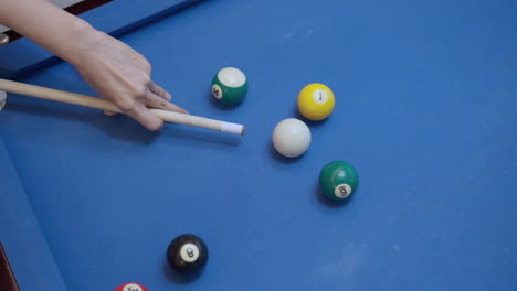 Player-Hand-Close-up-Aiming-and-Hits-white-Cue-Ball-Over-Blue-Pool-Table-in-Slow-Motion-Top-View