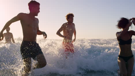 Eine-Vielfältige-Gruppe-Von-Freunden-Schwimmt-Bei-Sonnenuntergang-Im-Meer