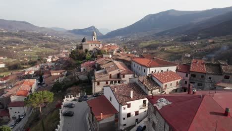 Aerial-forward-view-of-Calvario-village-with-streets-and-car-in-a-wide-valley