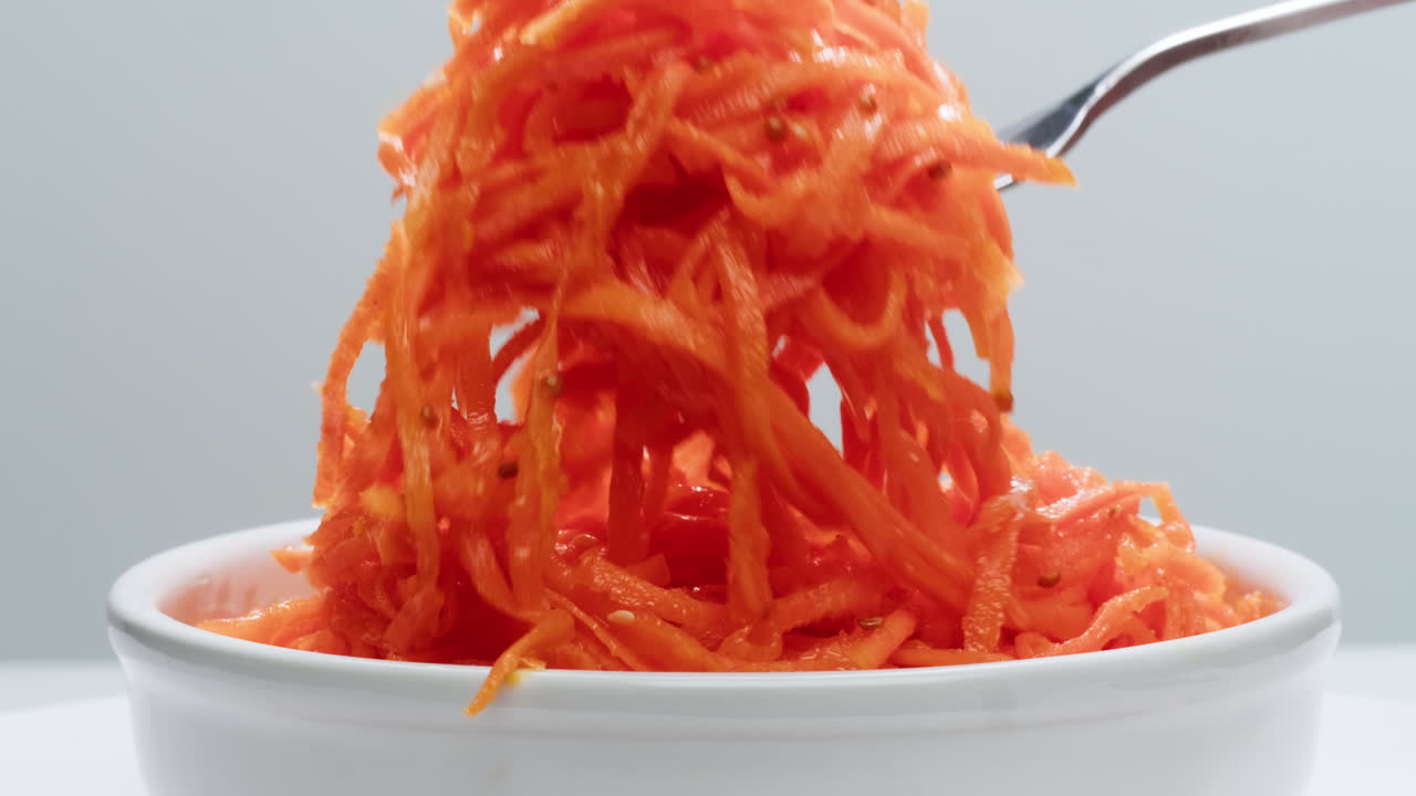 ensalada de zanahorias marinadas fermentadas, zanahorias picadas al estilo coreano, ajo, aceite vegetal y condimentos en una mesa giratoria