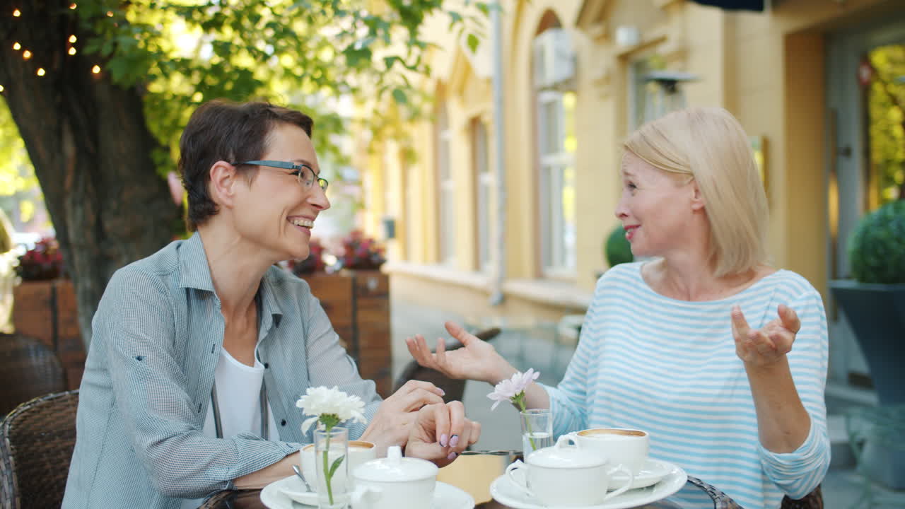 Two Women Enjoying Conversation at an Outdoor Cafe