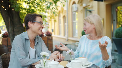 two women enjoying conversation at an outdoor cafe