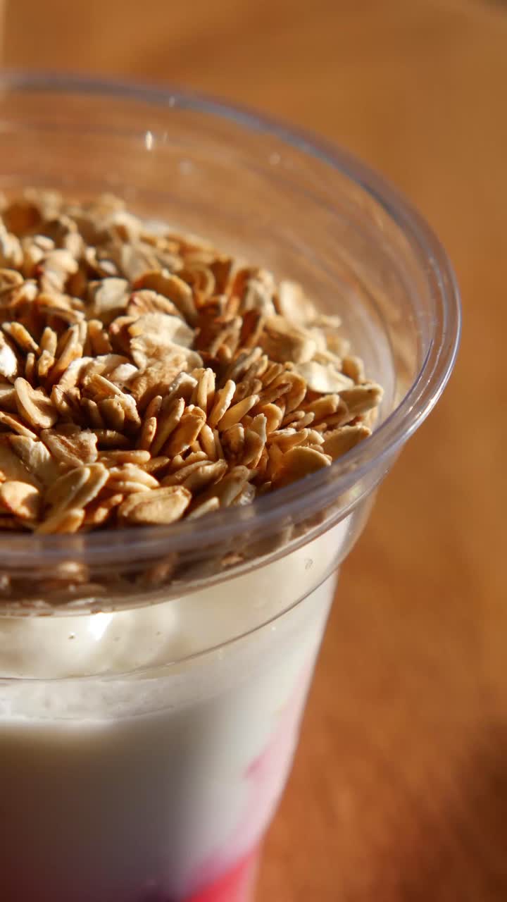 Primo piano di un salutare parfait di yogurt con avena e frutta.